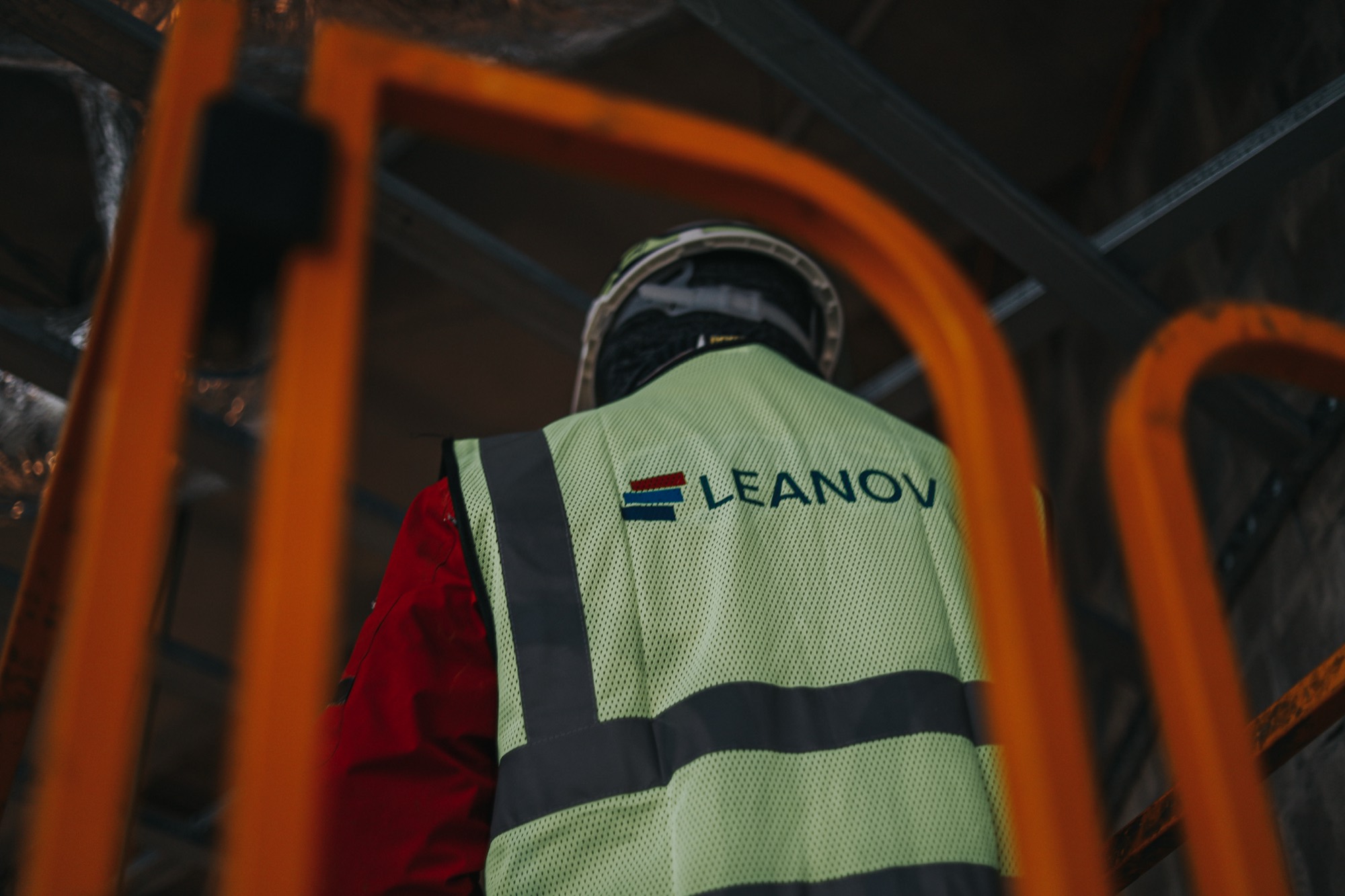 Colete refletor com logótipo LEANOV vestido por trabalhador em obra